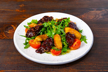Delicious salad with greens, dried fruit, and cherry tomatoes