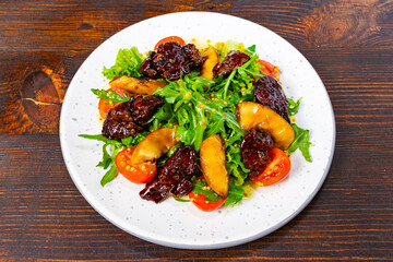 Colorful salad with apples and dried fruits on a wooden table
