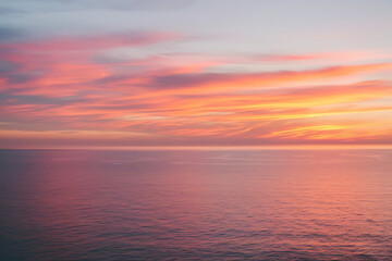 Fototapeta premium Stunning Sunset Sky Over Tranquil Sea: Vibrant Horizon Reflection