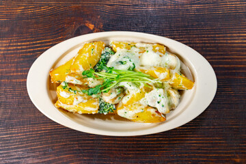 Baked potatoes with creamy broccoli and cheese sauce served warm