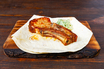 Baked pork ribs served on a rustic wooden platter