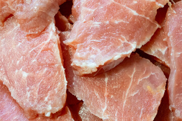 Freshly sliced pork meat arranged on a butcher's counter