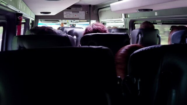 People ride in a passenger minibus inside, view from inside, background. Passenger transportation, travelers