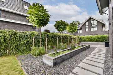 A contemporary garden featuring neatly arranged plants, stepping stone pathways, and lush greenery creates a serene outdoor space.