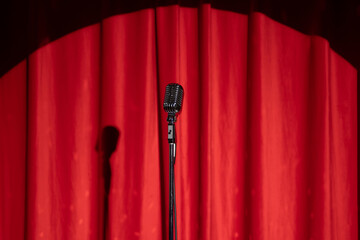 Concept stand up, comedian show banner. Old microphone on theater stage on red curtains background