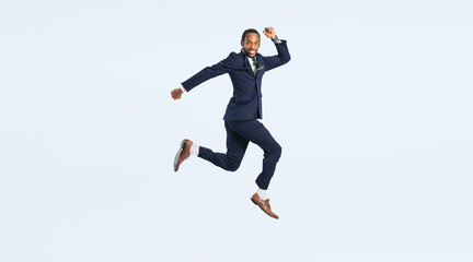 ジャンプする黒人男性ビジネスパーソンの全身写真（切り抜き背景透過PNGも販売しております。&darr;作成者リンクから「PNG」で検索してください）