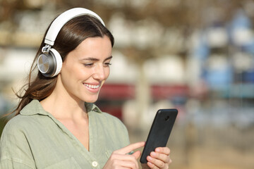 Happy woman wearing headphone using mobile phone