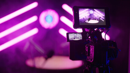 Behind the camera of podcast recording in dark pink neon tube studio LIVE ON AIR