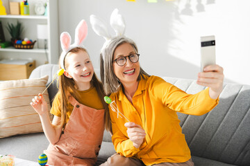 Grandmother and granddaughter taking easter selfie with bunny ears