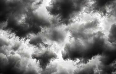 Obraz premium Abstract grayscale image of a stormy sky filled with dark and light gray clouds, creating a dramatic and moody atmosphere.