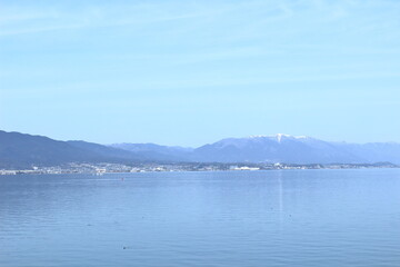 春の琵琶湖と雪の積もった蓬莱山