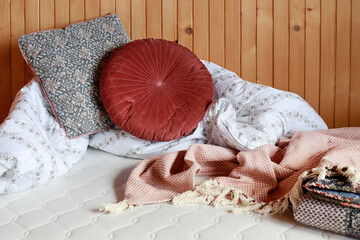 A cozy nook with pillows and a duvet in bed, on a new white mattress.