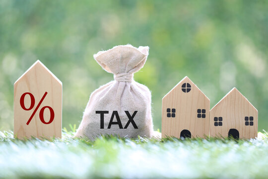 Estate tax, Model house and percentage symbol icon and stack of coins money on natural green background,Business investment and Property tax concept