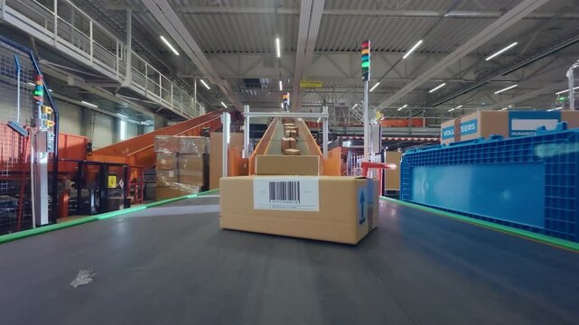 POV Footage on a Conveyor Line in a Logistics Center. Employees Sorting and Loading Parcels, Packages, Cardboard Boxes on a Conveyor Belt in a Postal Office or Retail Shop Warehouse Facility