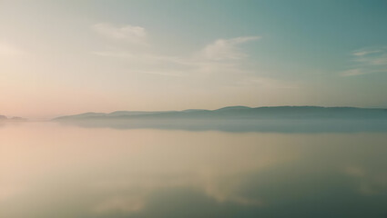 Naklejka premium Gentle mist blankets a tranquil landscape at dawn, where soft colors intertwine in the sky and ground. The ambiance feels peaceful and enchanting, inviting reflection and serenity