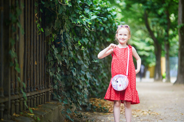 Adorable preschooler girl walking in park in Paris, France.