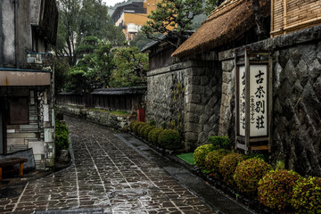 Fototapeta premium 雰囲気の良い古い温泉街の石畳が静かに雨に濡れて黒く見える