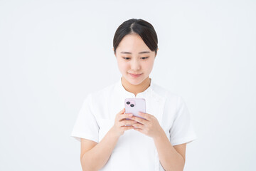 スマホを使う看護師の若い女性