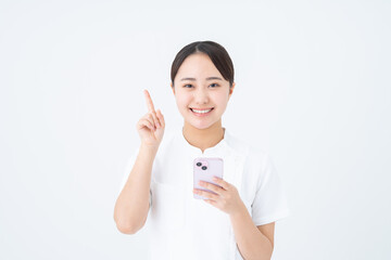 スマホを使う看護師の若い女性