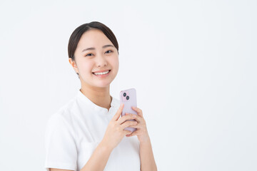 スマホを使う看護師の若い女性