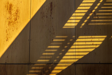 A yellow brick building facade features raised rectangular black iron elements, echoing the brick...