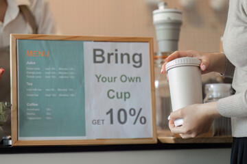 Promotion of Eco-Conscious Choices. A barista highlights the benefits of bringing your own cup for a sustainable lifestyle.