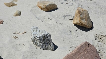 stones contrast with pristine white sand on a Cape Town beach