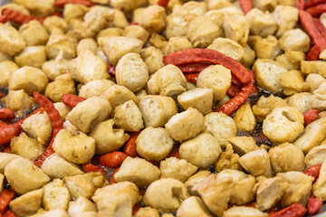Deep frying meatballs and sausage in pan by oil. Local Thai street food and appetizer.