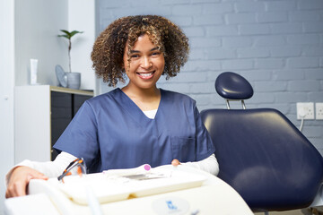 Naklejka premium Smiling Female Dental Professional in a Modern Dental Office Setting with Equipment