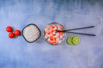 arrangement of fresh ingredients for asian style dish including glass bowl filled with boiled...