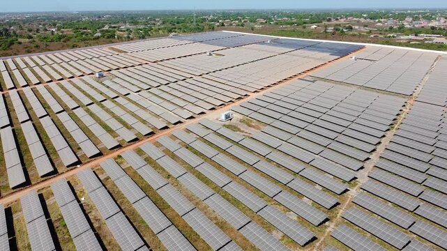 High angle reverse overview of solar field inverters and very dirty panels arrays