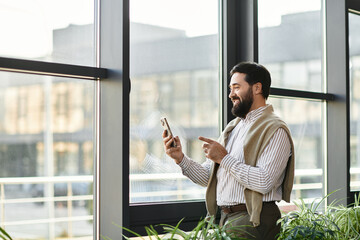 Charming elderly man enjoying a sunny day while checking his smartphone by a window