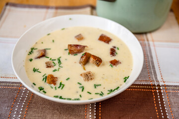 Roasted garlic soup with chive in plate.