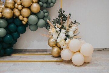 Elegant balloon arch with floral arrangements.