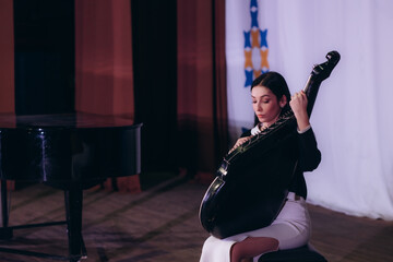 Young Woman Playing Double Bass on Stage During a Musical Performance