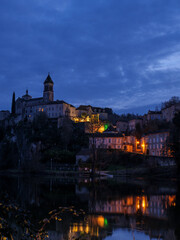 Fototapeta premium illuminated Albas Church village reflecting Lot River night cloudy sky