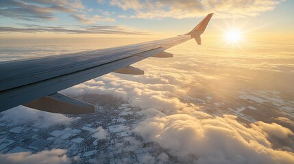 Obraz premium An airplane wing glides above fluffy clouds toward bright sunlight