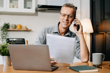 Mature businessman working online from home, small business lifestyle.