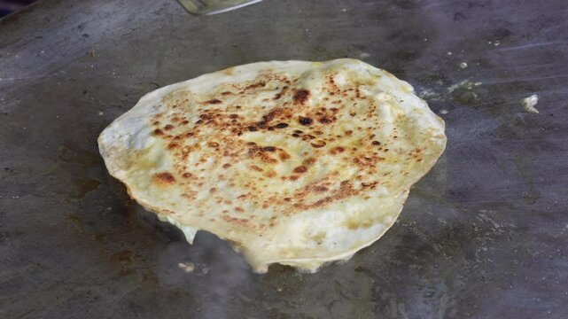 street food in India, eggroll preparing on the oven closeup