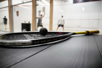 squash racket with ball close up, laying on table, preparing for game. court background, live pictures