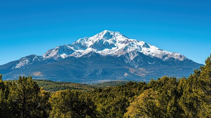 A breathtaking view of a snow-capped high mountain peak under a clear blue sky