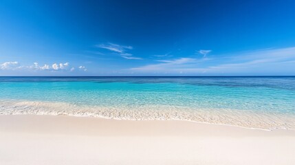 Fototapeta premium a pristine beach with crystal clear water under a bright blue sky.