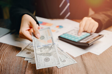 Businessperson Handling Cash and Using Calculator for Financial Transactions, Business concept