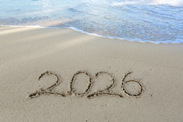 2026 hand written in sand on a beautiful beach