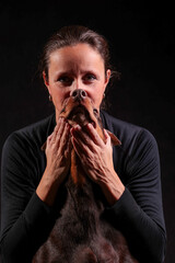 three women with a Doberman dog whose nose and snout merge into one