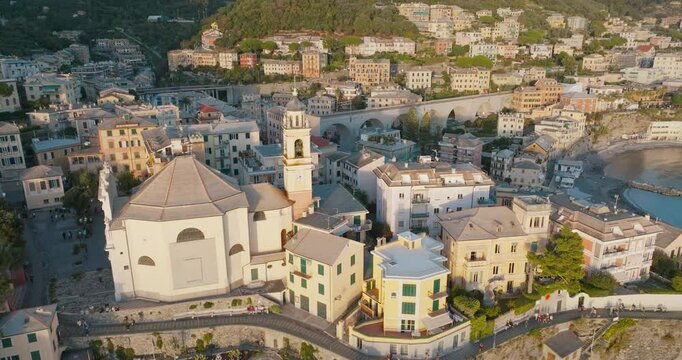 Discover the historical texture of Bogliasco! The drone image gliding towards the coast reveals a fascinating view of the Mediterranean Sea with churches, colorful houses and an arched viaduct.