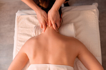 Professional back massage for a woman in a beauty salon. Relaxation, wellness, and self-care concept