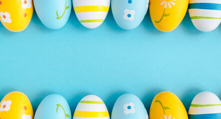 Easter poster. Blue, yellow and white Easter eggs on a light blue background. Top view. Flat lay.