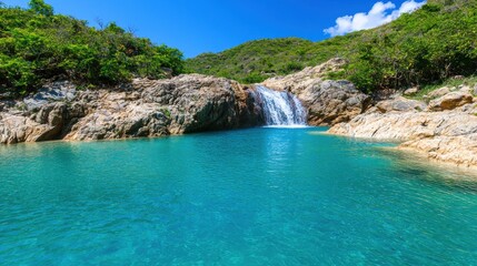 Obraz premium Captivating Remote Blue Waterfall Surrounded by Lush Greenery Under Clear Blue Sky