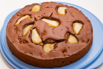 Home made pear cake with chocolate on blue plate. White background.